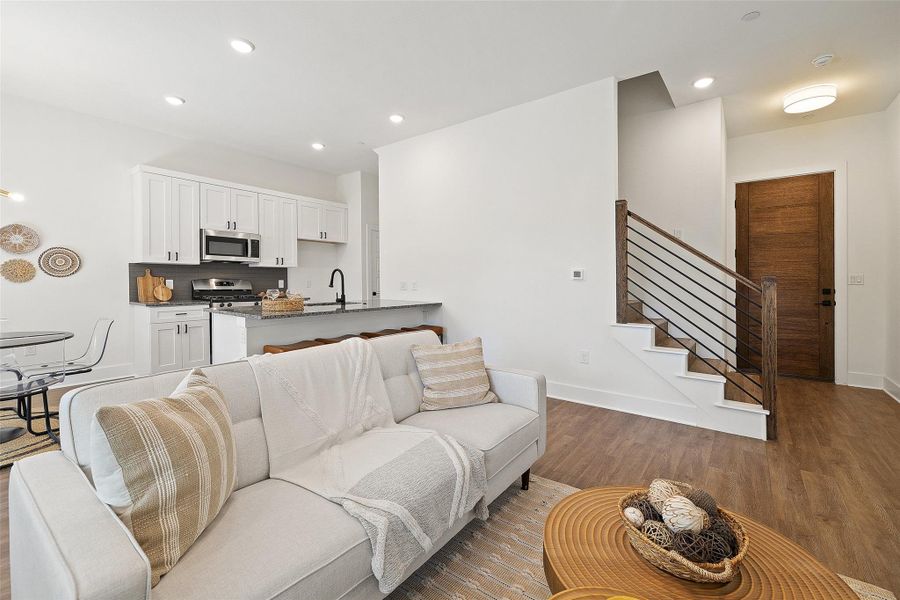 Living room featuring wood finished floors, recessed lighting, and stairs Living room featuring wood finished floors, recessed lighting, and stairs
