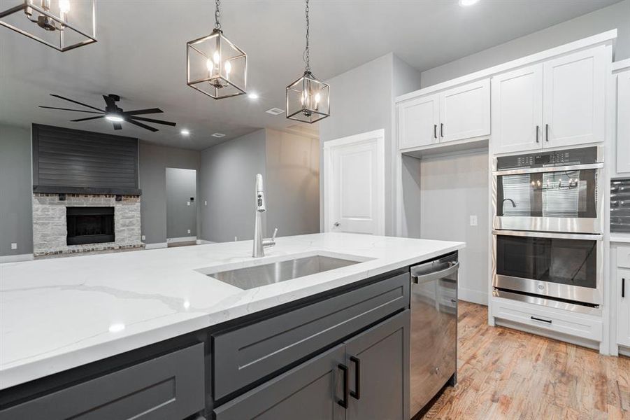 Kitchen with a sink, appliances with stainless steel finishes, gray cabinets, and ceiling fan with notable chandelier Kitchen with a sink, appliances with stainless steel finishes, gray cabinets, and ceiling fan with notable chandelier