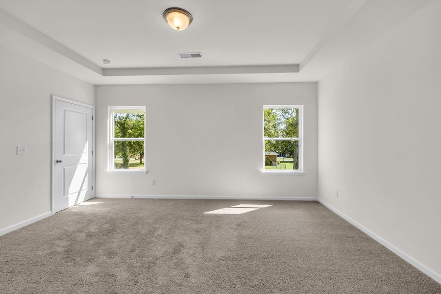 Primary bedroom with beautiful tray ceilings.