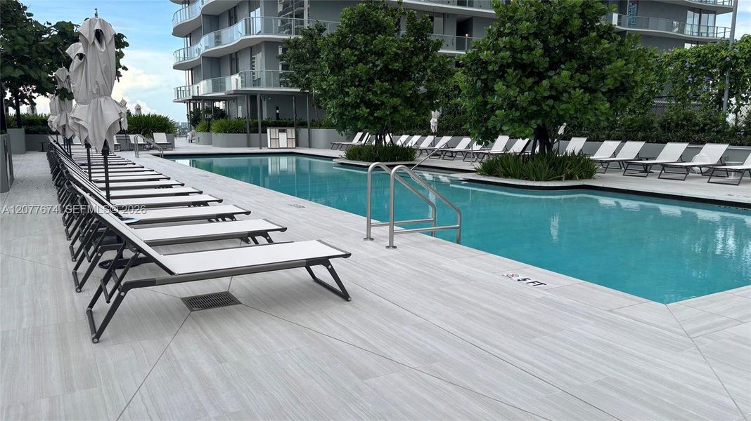 Resort Pool Surrounded by Lush Landscaping and Loungers Resort Pool Surrounded by Lush Landscaping and Loungers