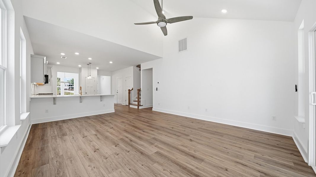 First-class living space featuring expansive ceilings, elegant design, and open sightlines to the kitchen First-class living space featuring expansive ceilings, elegant design, and open sightlines to the kitchen