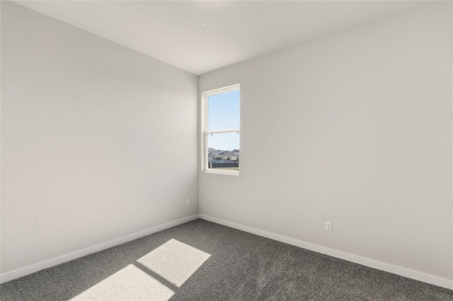 Spare room with carpet and baseboards