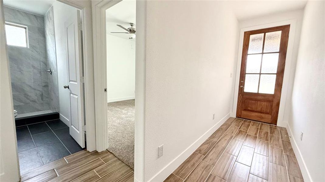 Entryway, a healthy amount of sunlight, baseboards, and wood finish floors