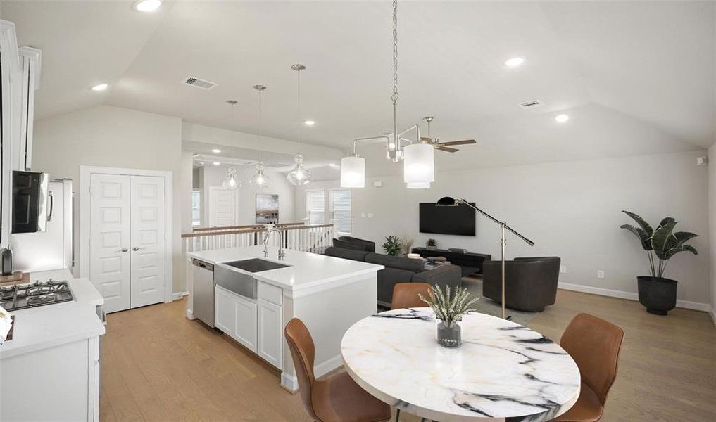 The quartz island countertop space features a deep stainless steel sink and dishwasher.