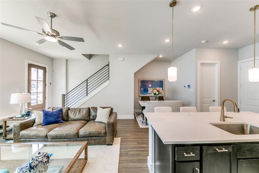 Living room featuring ceiling fan, sink, and dark hardwood / wood-style floors