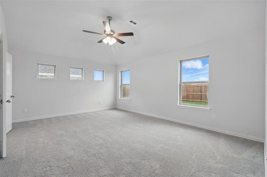 Empty room with light carpet, ceiling fan, and lofted ceiling