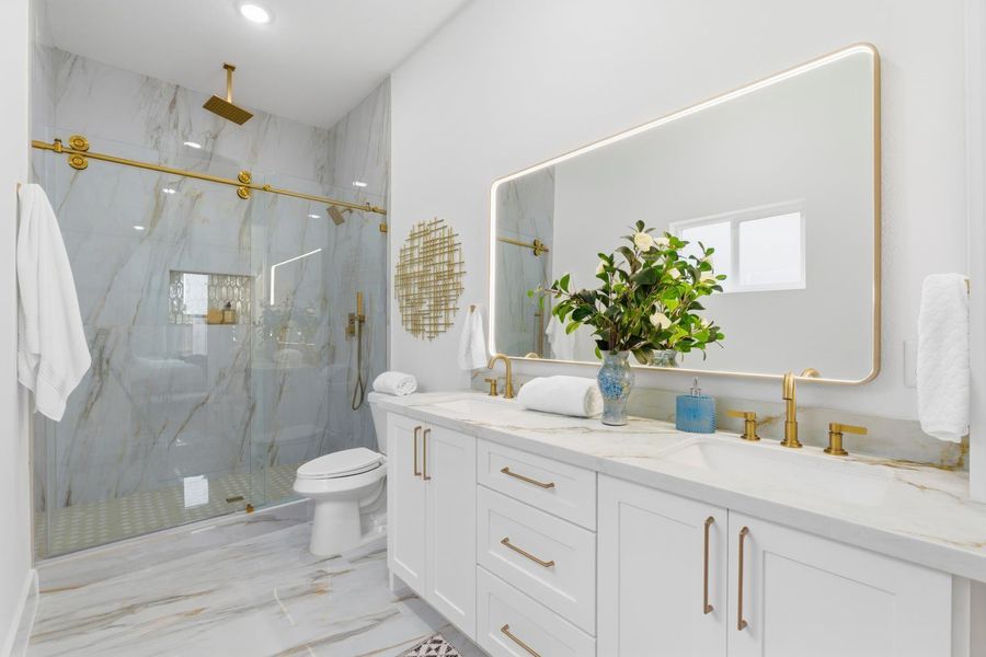 A spacious primary suite designed for comfort, complete with an oversized walk-in shower, dual vanities, and generous storage.