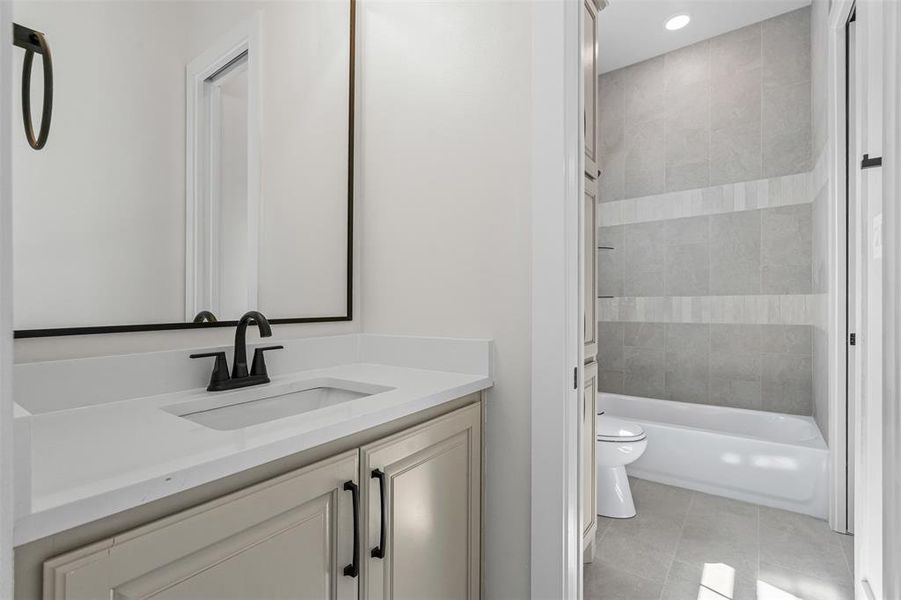 Bathroom with vanity, shower / washtub combination, and light tile patterned flooring