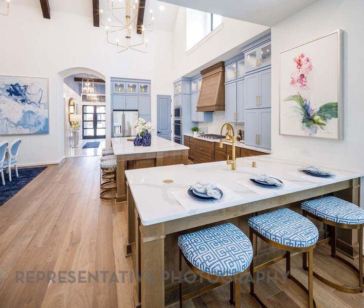 Kitchen with a chandelier, appliances with stainless steel finishes, premium range hood, a breakfast bar, and a peninsula Kitchen with a chandelier, appliances with stainless steel finishes, premium range hood, a breakfast bar, and a peninsula