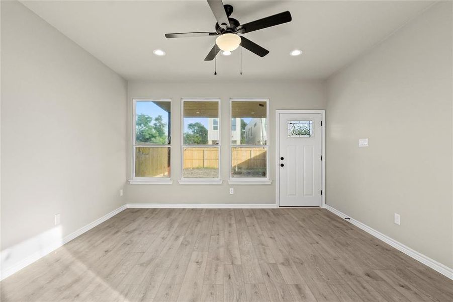 Unfurnished living room featuring ceiling fan and light hardwood / wood-style floors