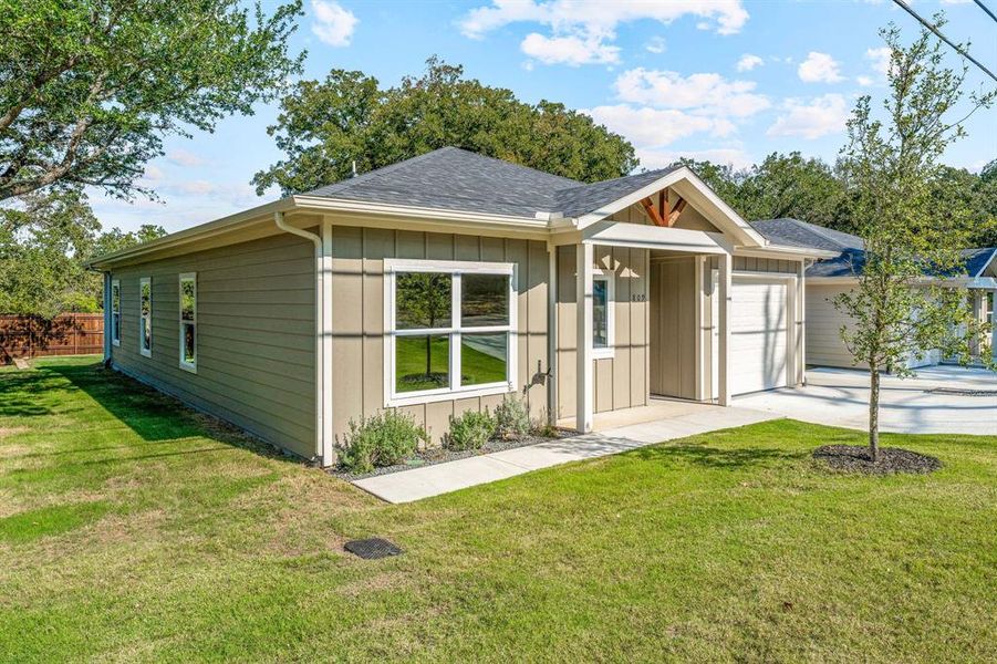 Ranch-style house with a front lawn, a shingled roof, board and batten siding, a garage, and concrete driveway Ranch-style house with a front lawn, a shingled roof, board and batten siding, a garage, and concrete driveway