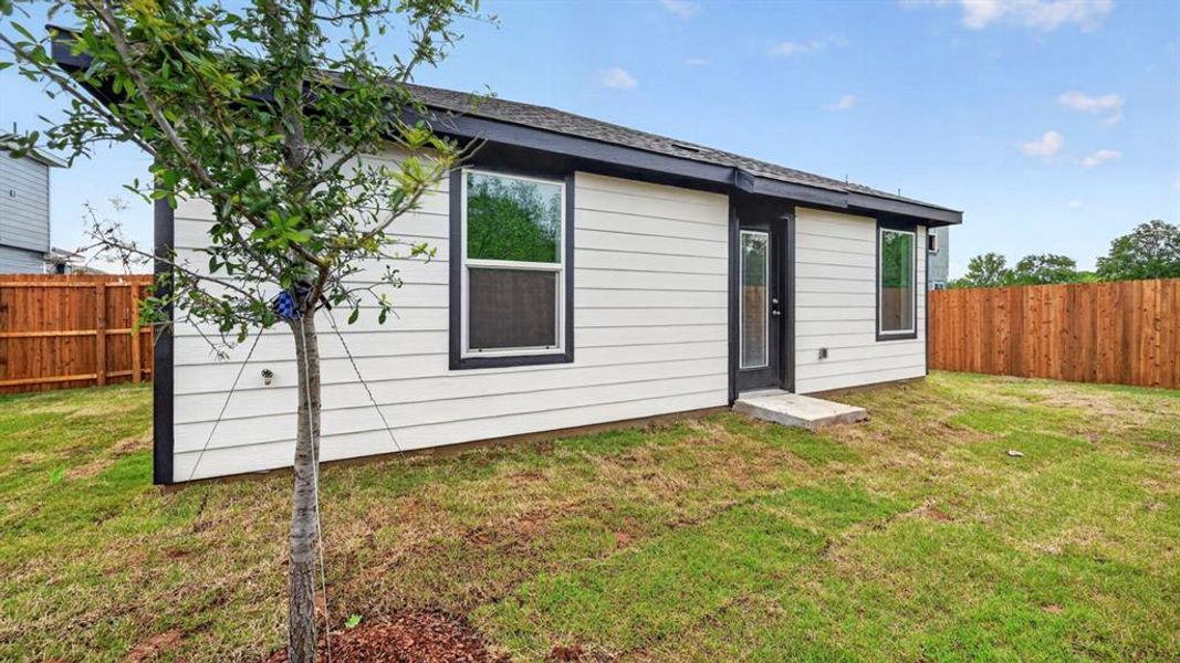 Rear exterior featuring white horizontal siding, black trim, and a full-light back door