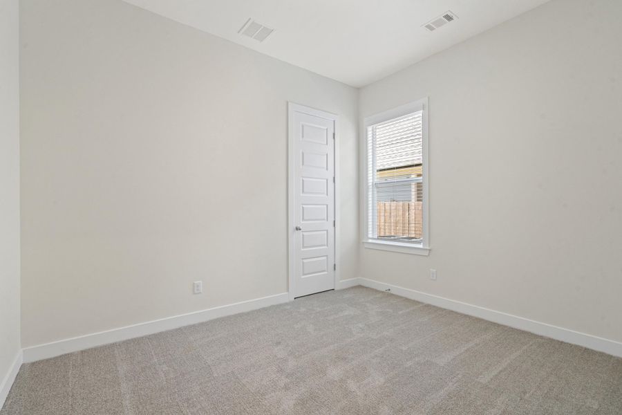 Neutral-toned interior room featuring light gray carpet flooring and white baseboards Neutral-toned interior room featuring light gray carpet flooring and white baseboards
