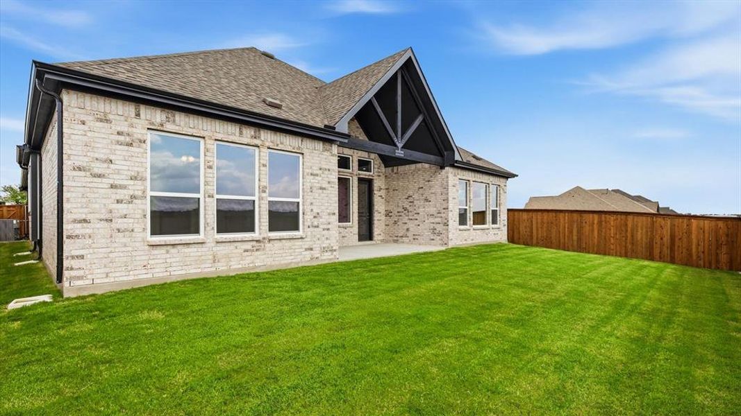Expansive green lawn with a newly constructed brick exterior