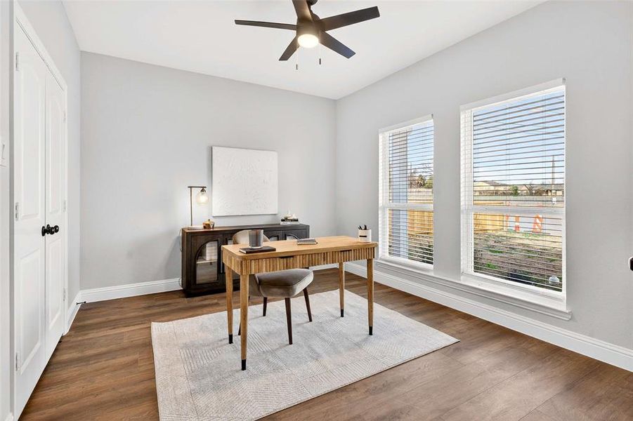 Home office with dark wood-style floors and ceiling fan