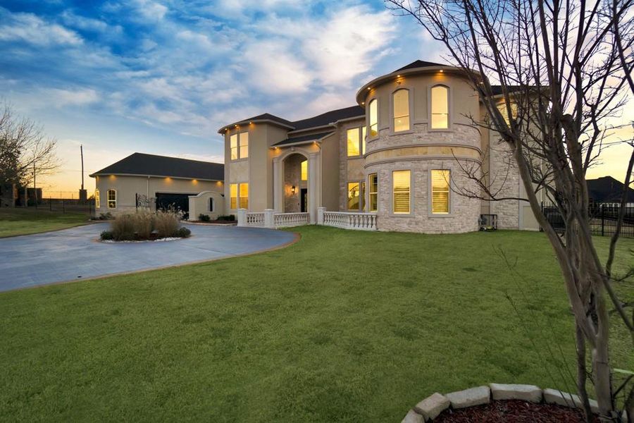 View of front of property with a garage and a lawn