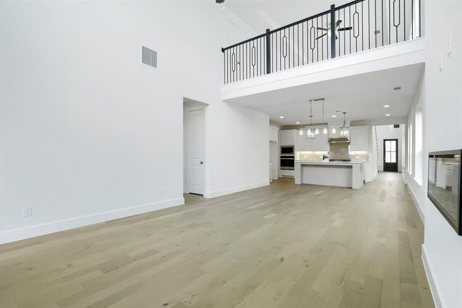 Spacious open-concept living area with light wood-finish flooring