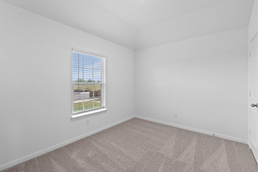 Empty room with light colored carpet and baseboards