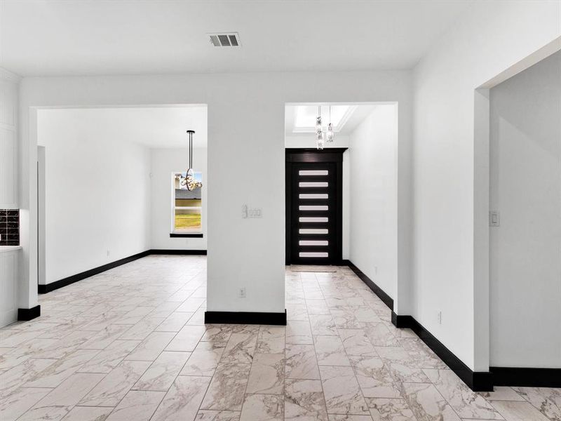 Spacious interior featuring patterned tile flooring and contrasting black baseboards