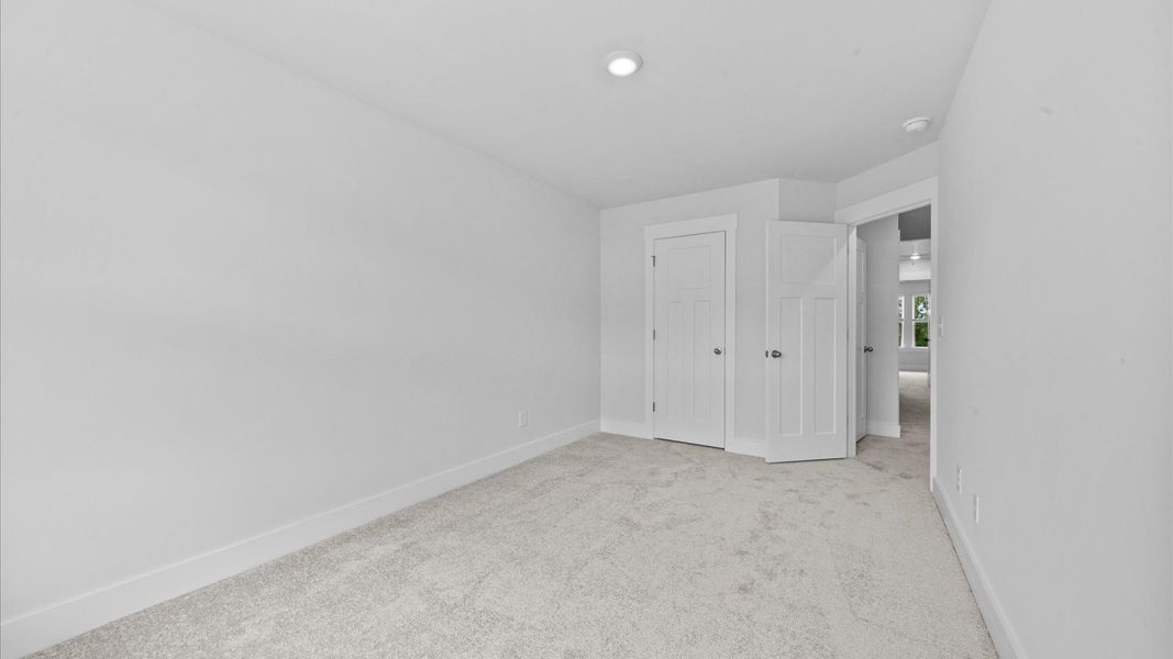 Carpeted bedroom with walk-in closet in two story townhome at Ransdell Pointe by DRB Homes in Spartanburg, SC