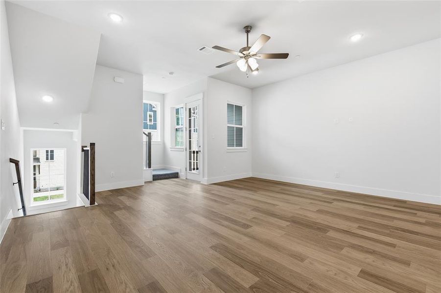 Open concept living area featuring light wood flooring, a ceiling fan, and recessed lighting