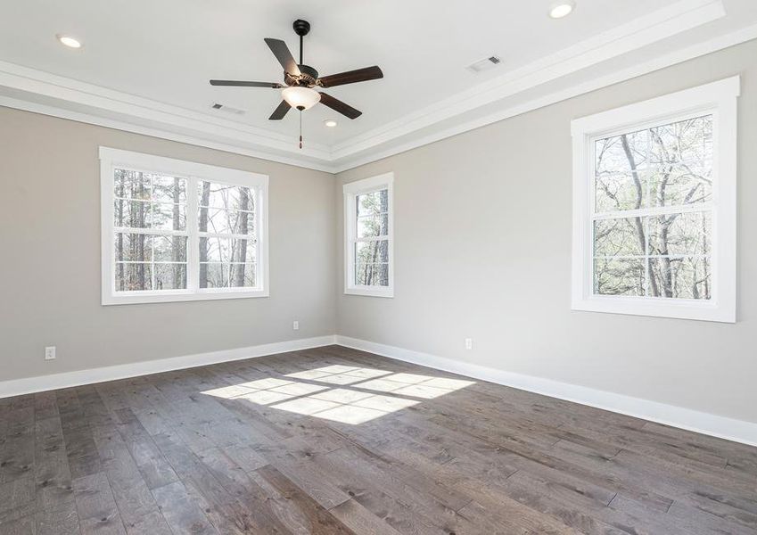 Unwind at the end of the day in the master bedroom which showcases an array of windows and wood floors.