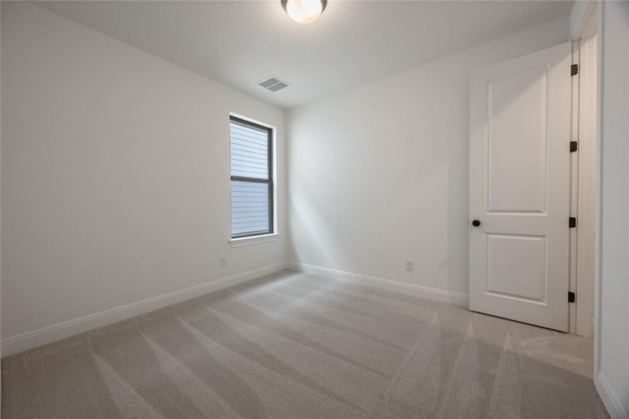 Empty room featuring light colored carpet and baseboards Empty room featuring light colored carpet and baseboards