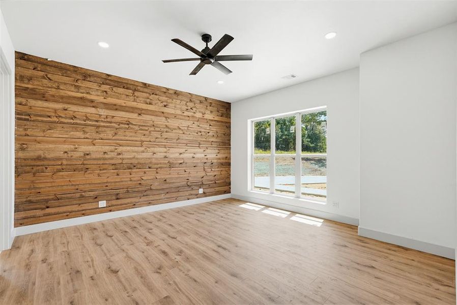 Primary bedroom with wood paneled wall Primary bedroom with wood paneled wall