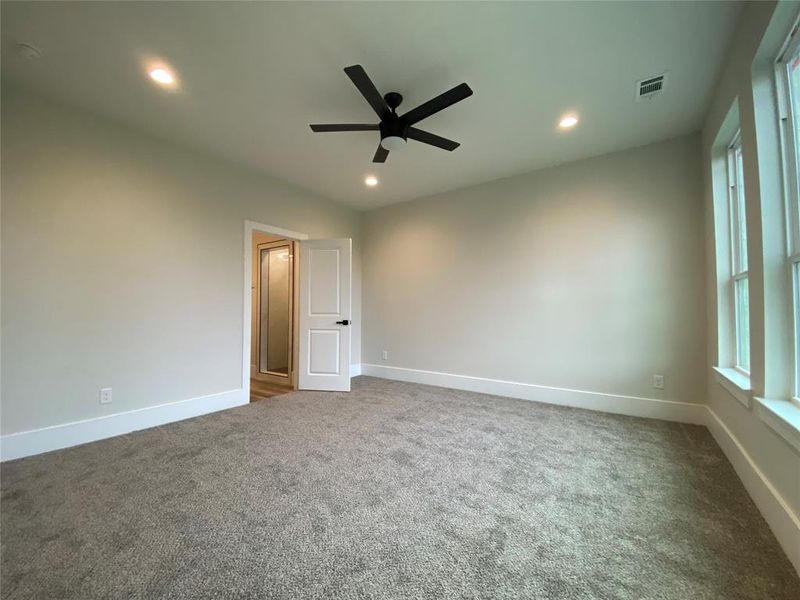 Carpeted spare room featuring ceiling fan