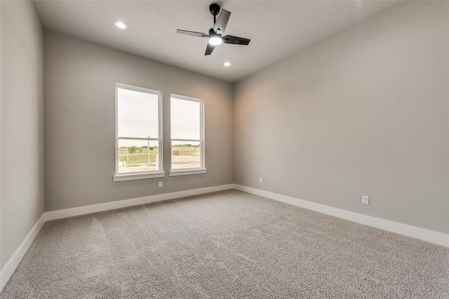 Unfurnished room featuring ceiling fan and carpet floors