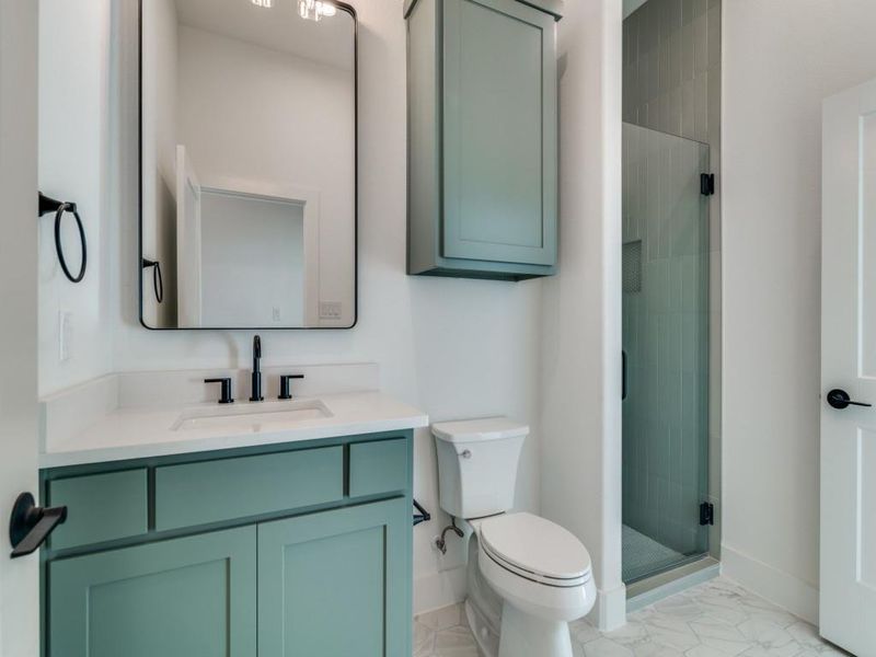 Full bathroom featuring a stall shower, vanity, and light marble finish floors