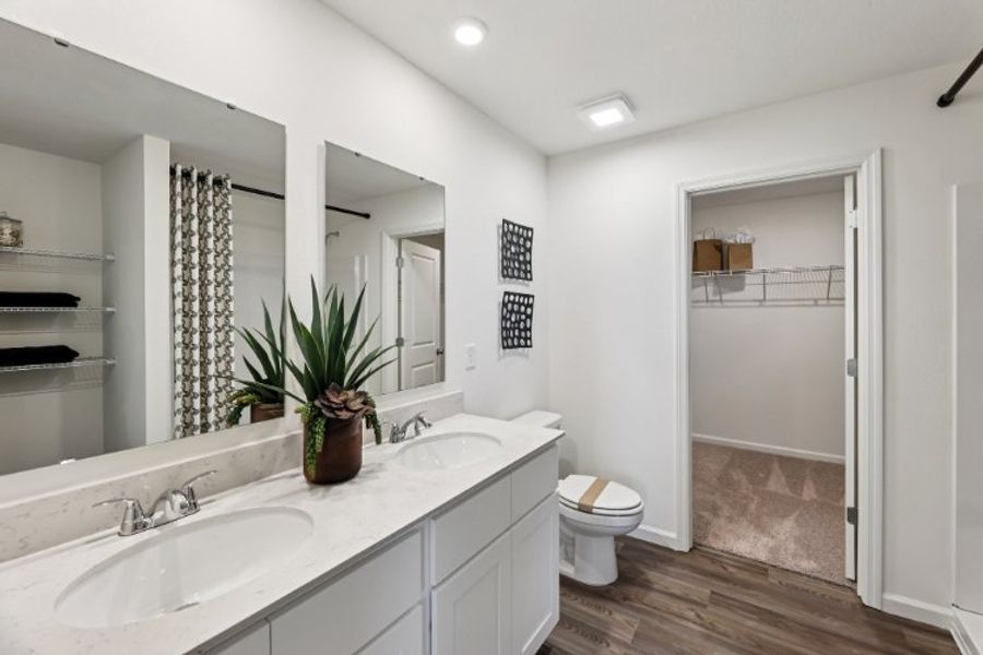 A bathroom with a sink toilet and a mirror. A bathroom with a sink toilet and a mirror.
