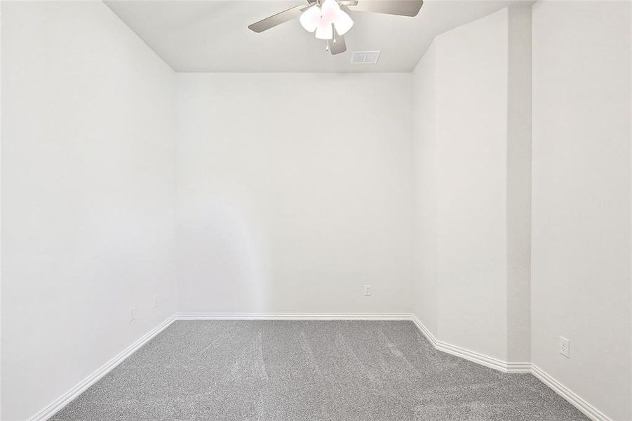 Carpeted spare room with ceiling fan