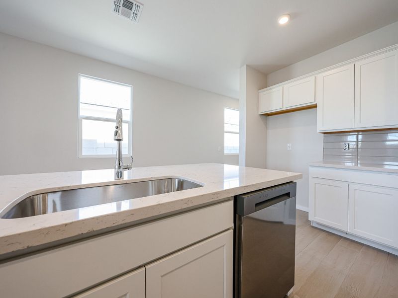 A kitchen with white cabinets.