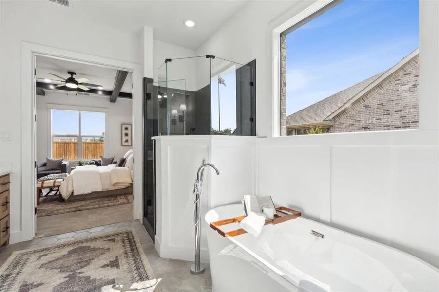 Ensuite bathroom with a shower stall, a ceiling fan, a freestanding tub, vanity, and light tile patterned floors