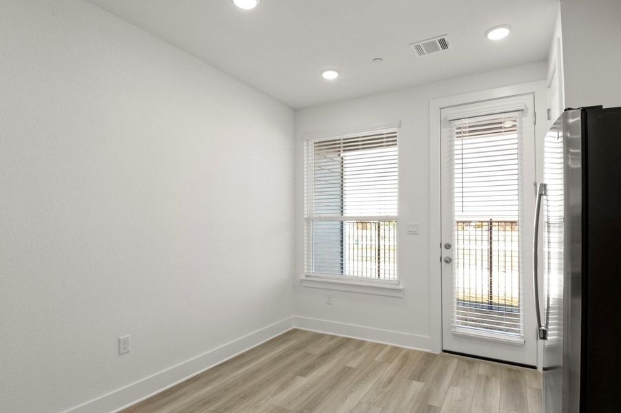 Empty room with light wood-type flooring and recessed lighting