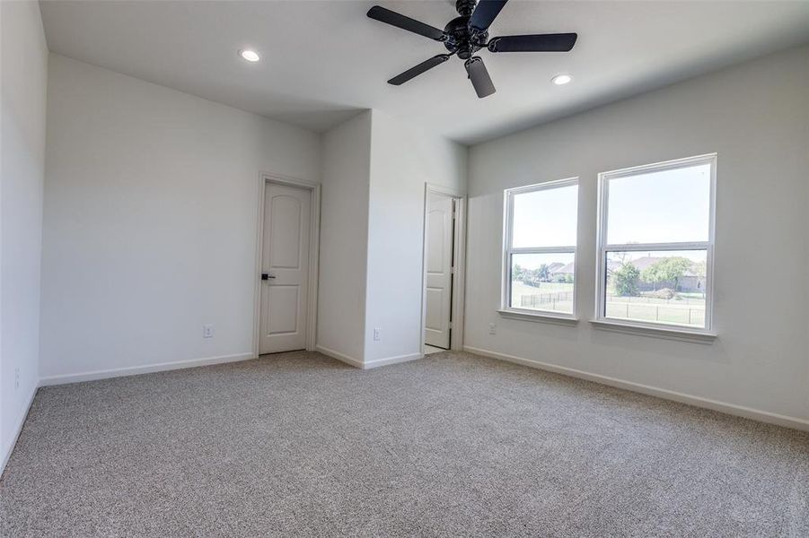 Unfurnished bedroom with ceiling fan and light carpet