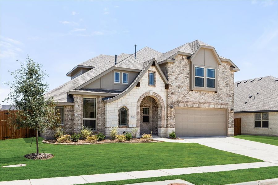 Two-story brick and stone home with arched entry, two-car garage, and manicured front lawn Two-story brick and stone home with arched entry, two-car garage, and manicured front lawn