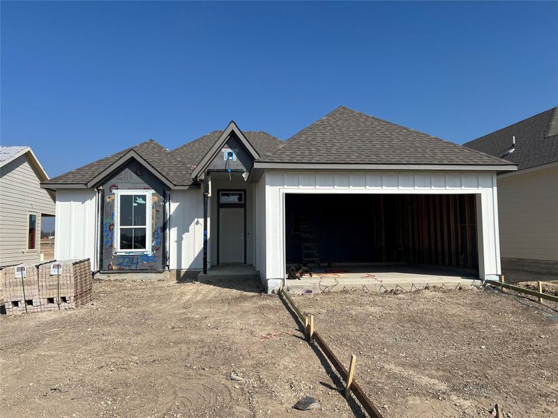 View of front facade with board and batten siding and a shingled roof