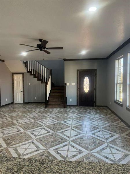 Foyer featuring stairway and ceiling fan