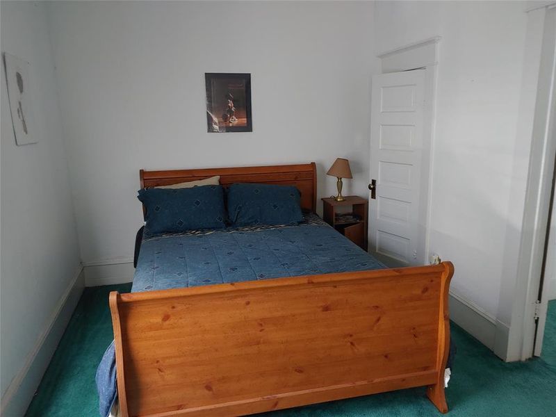 Room featuring white painted walls and trim, with a panel door Room featuring white painted walls and trim, with a panel door