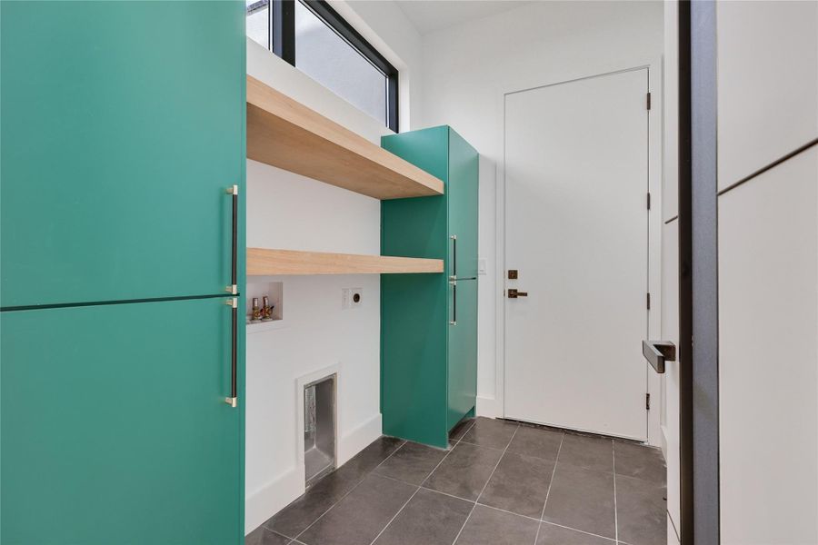 Laundry area featuring hookup for an electric dryer, dark tile patterned flooring, and washer hookup