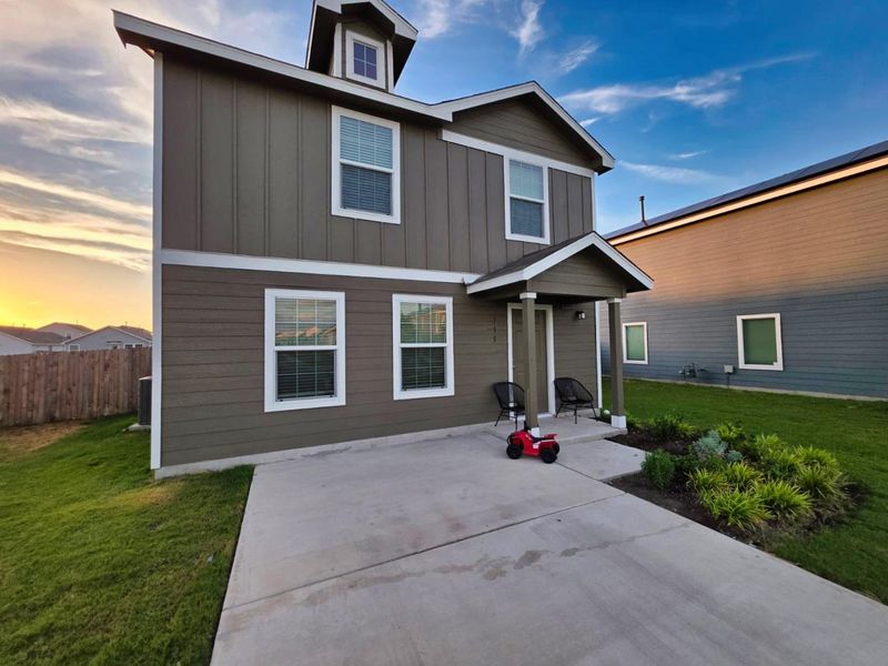 View of front of house with a front lawn, board and batten siding, and a patio area View of front of house with a front lawn, board and batten siding, and a patio area