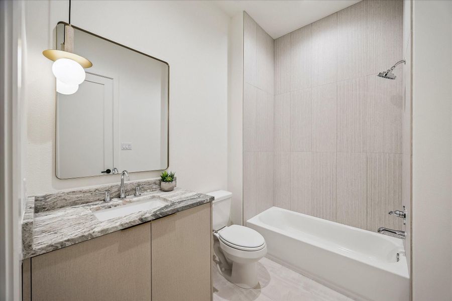 En-suite bath #4 - features a shower/tub combo, designer lighting fixture, and dual access from the bedroom and hallway. En-suite bath #4 - features a shower/tub combo, designer lighting fixture, and dual access from the bedroom and hallway.