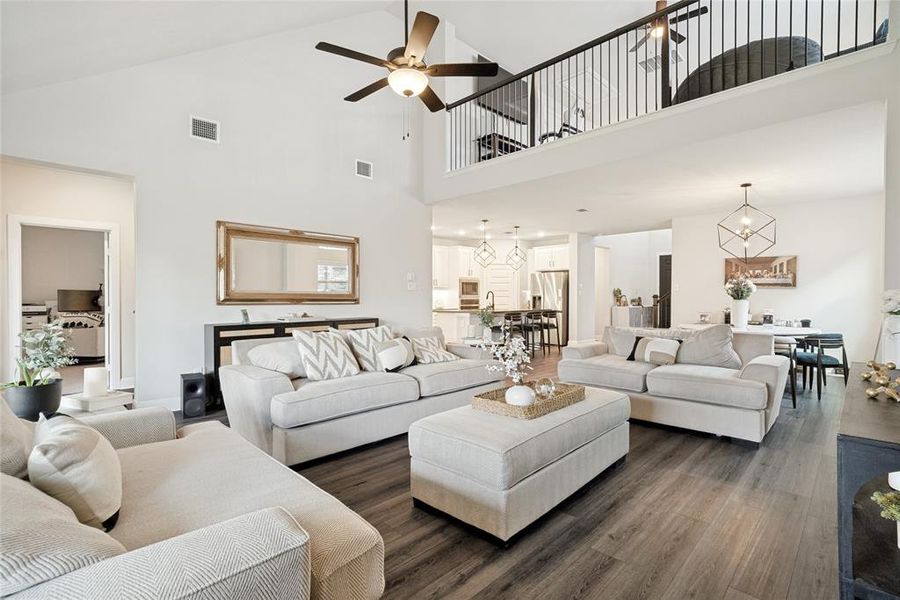 Spacious living area featuring high vaulted ceilings, wood-finish flooring, and an open-concept design