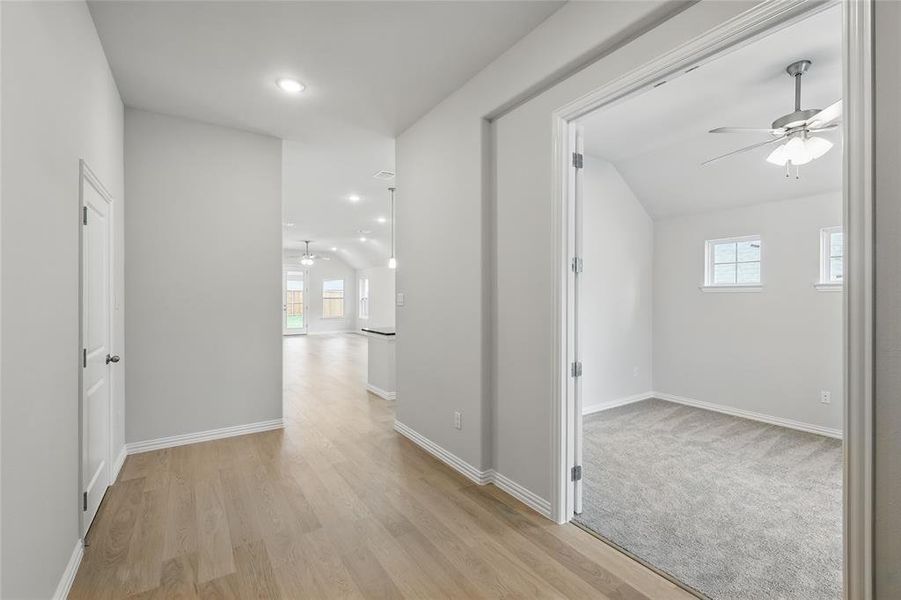 Hall with vaulted ceiling, light wood finished floors, and recessed lighting Hall with vaulted ceiling, light wood finished floors, and recessed lighting