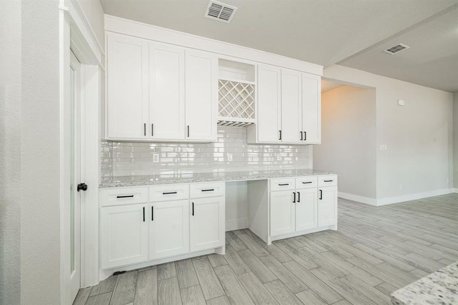 Kitchen cabinets with wine glass rack, wine/soda frig (to be installed), and plenty of granite countertop with coordinating tile backsplash Kitchen cabinets with wine glass rack, wine/soda frig (to be installed), and plenty of granite countertop with coordinating tile backsplash