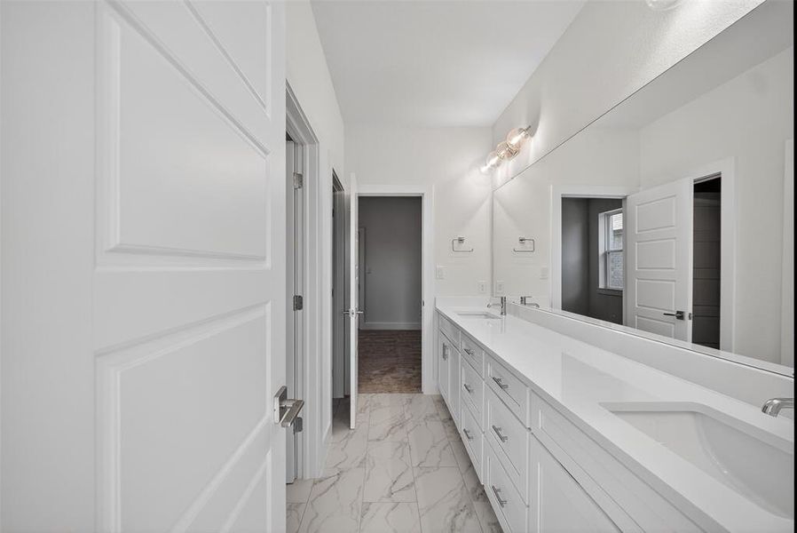 Full bathroom featuring double vanity and light marble finish flooring Full bathroom featuring double vanity and light marble finish flooring