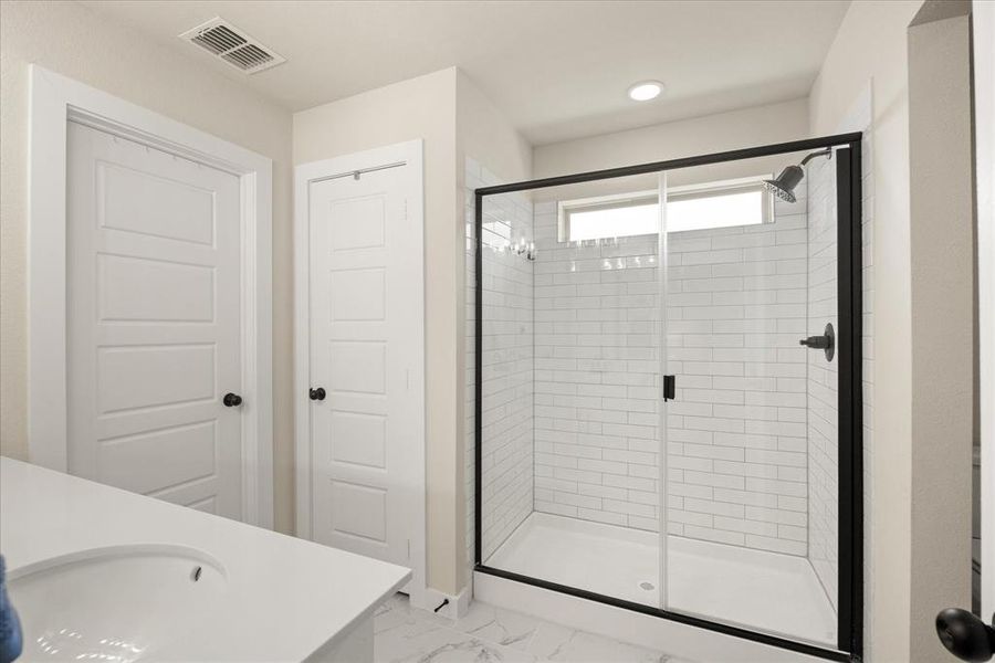 Bathroom with a shower stall, vanity, and light marble finish flooring