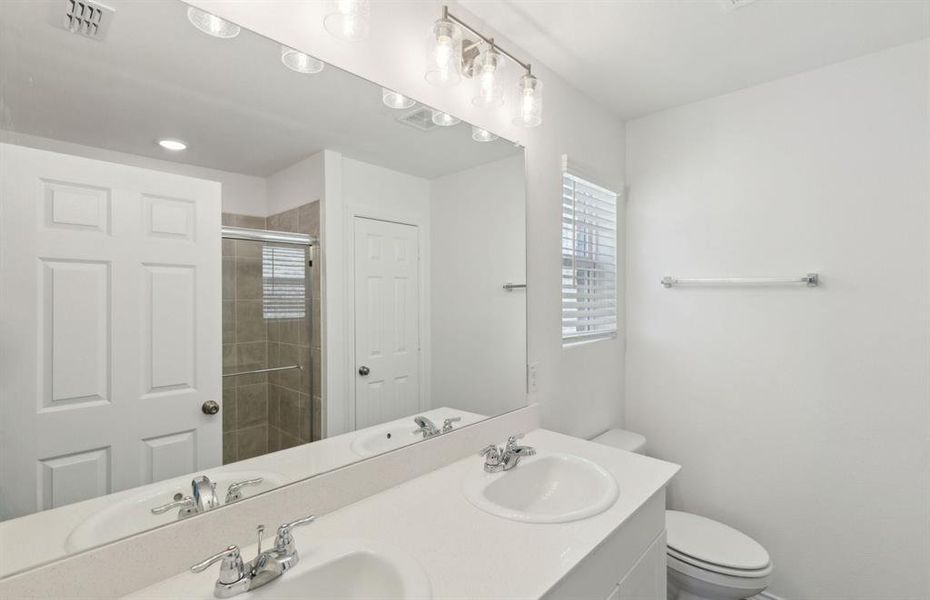 Elegant owner's bathroom with dual vanity *real home pictured